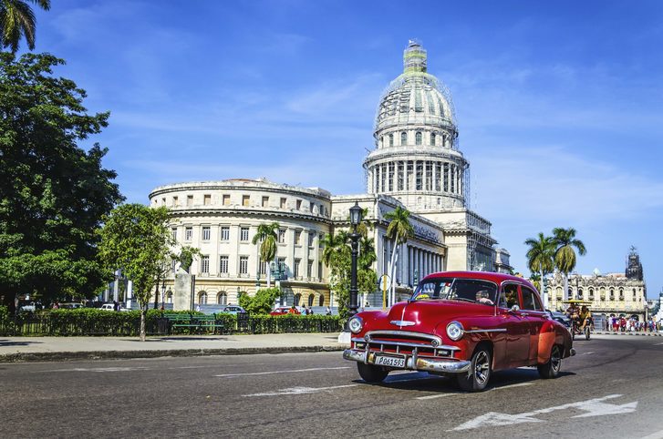 Panoramatický výhled na centrum Havany s budovou Kapitolu a klasickými americkými auty, Kuba