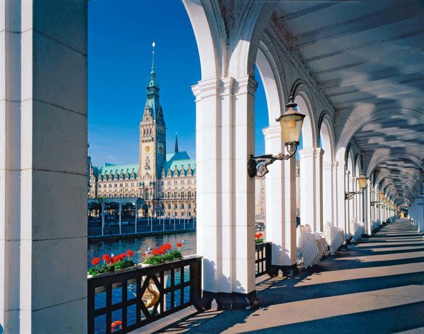 Alsterarkaden u jezera Kleine Alster v Hamburku, pohled na historickou hamburskou radnici, Německo