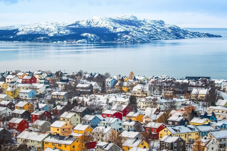 Kirkenes - Zasněžené barevné domy u klidné zátoky v Kirkenes 