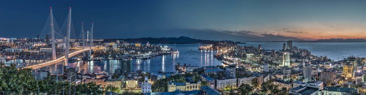 Večerní Vladivostok z výšky, panoramatický výhled na záliv Zlatý roh a Zlatý most