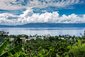 Pohled na tropickou mořskou krajinu, modré nebe s bílými mraky nad Alotau