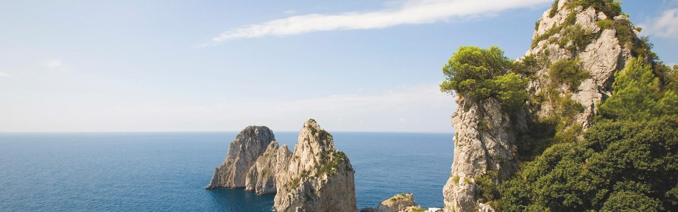 Svitanie pri ostrove Capri s pohľadom na Faraglioni
